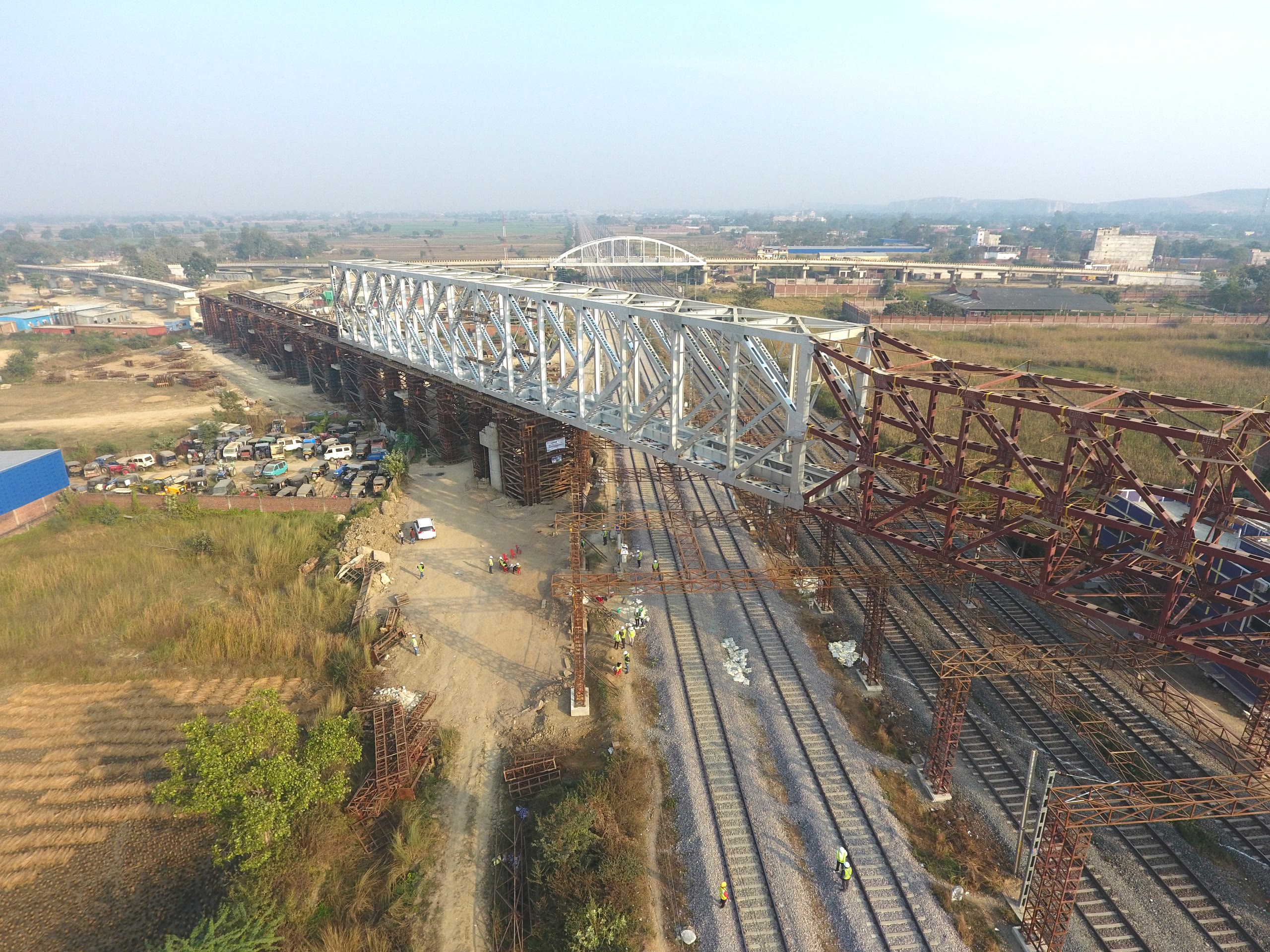 Steel truss span being launched over a running railway line